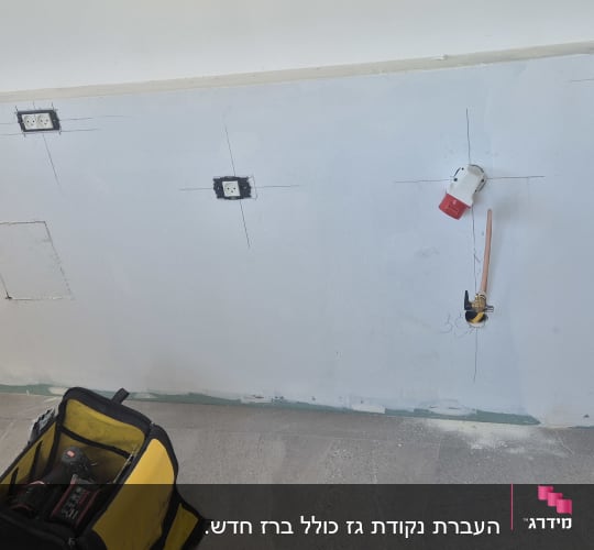 שקעים חשמליים על קיר, תיק עבודות כלים על הרצפה
